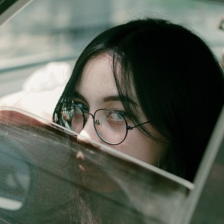 Frau schaut durch ein offenes Autofenster